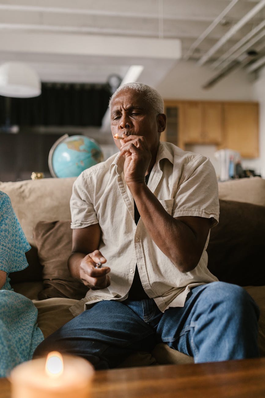 a man sitting on the couch smoking