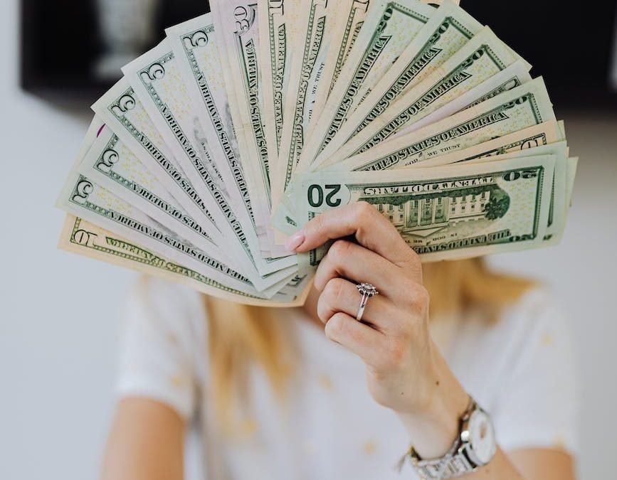 person holding fan of us dollar bills