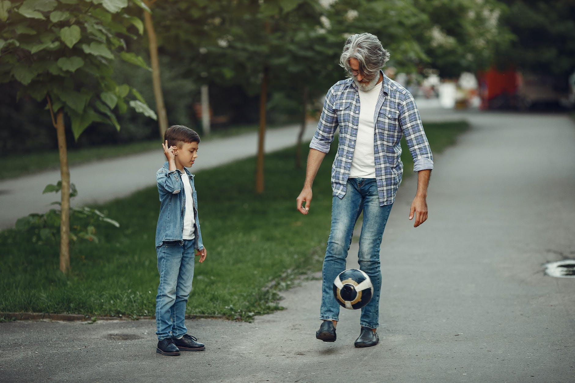 elderly man and boy playing with ball outdoors