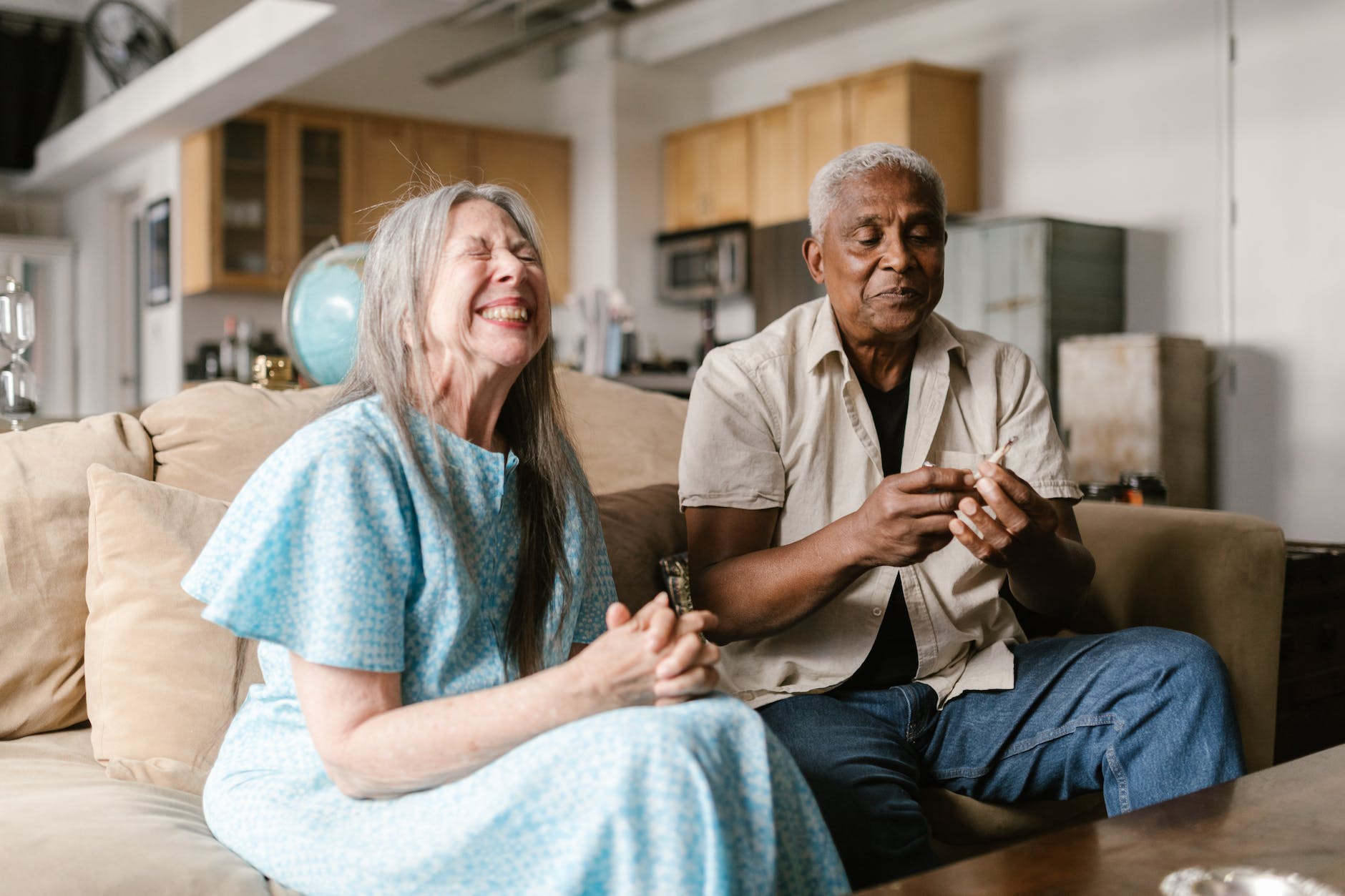 happy elderly woman sitting on a beige sofa