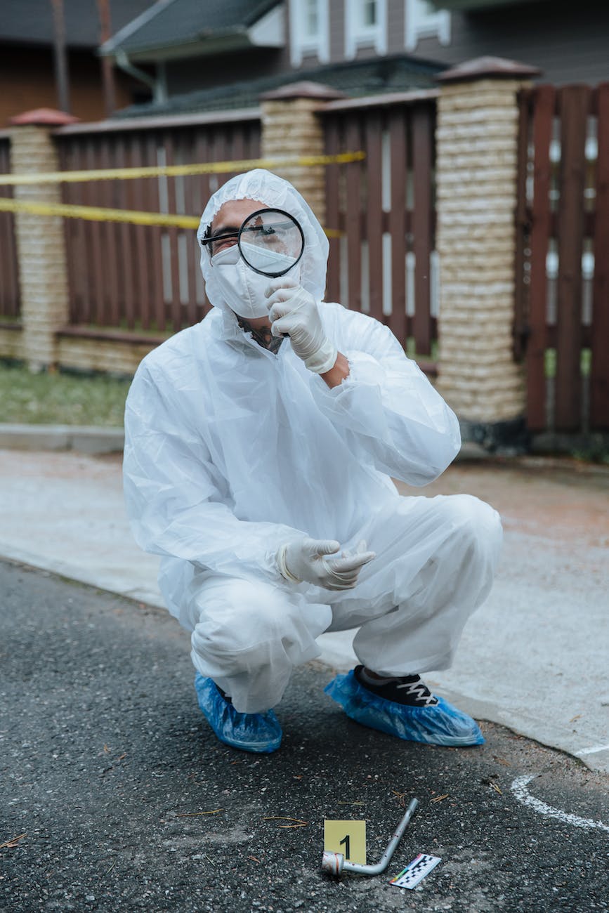 investigator on crime scene looking through magnifying glass