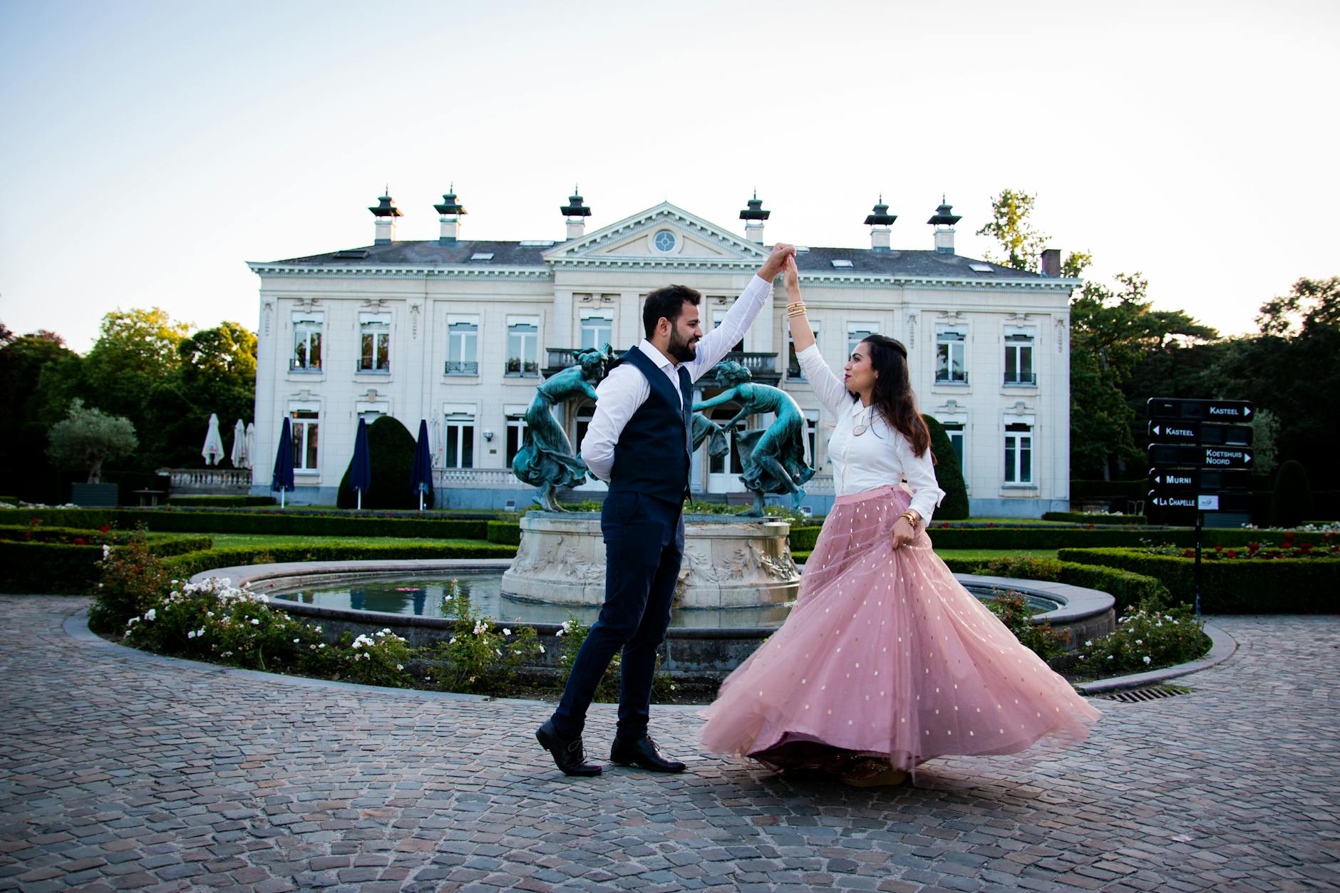 man and woman dancing in front of a fountain