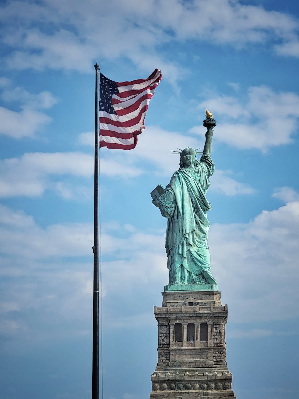 statue of liberty with american flag on a clear day
