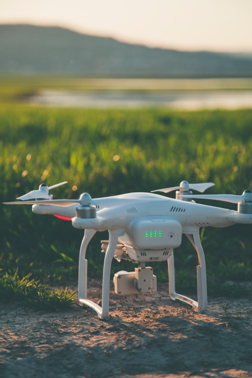 white and gray quadcopter on ground