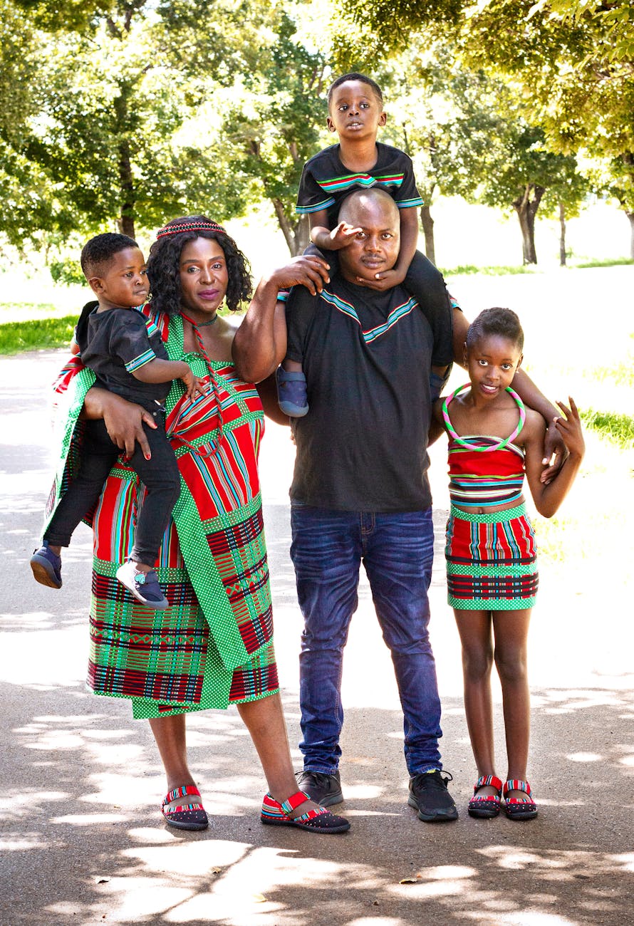 a family poses for a photo in a park