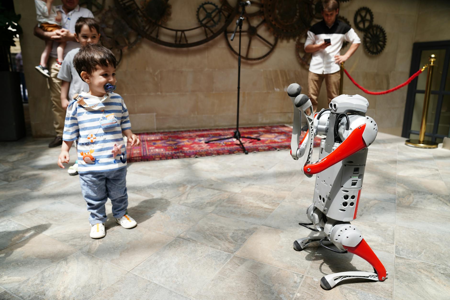 child interacting with humanoid robot at exhibition