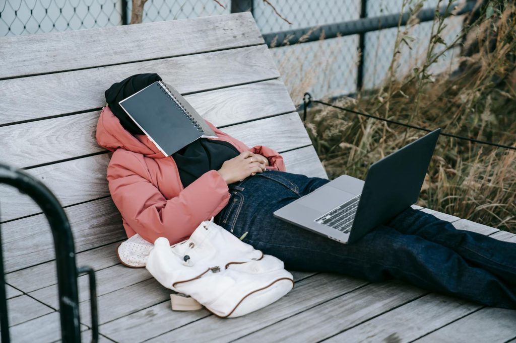 Current image: unrecognizable woman with laptop resting on bench in park