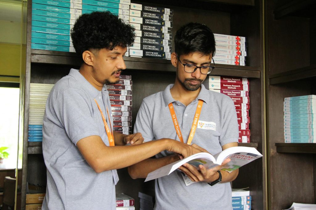 Current image: college students discussing study material in library