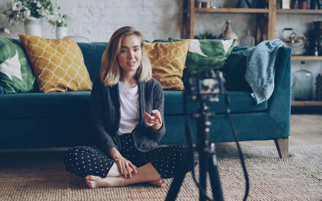young woman vlogging at home on sofa setup