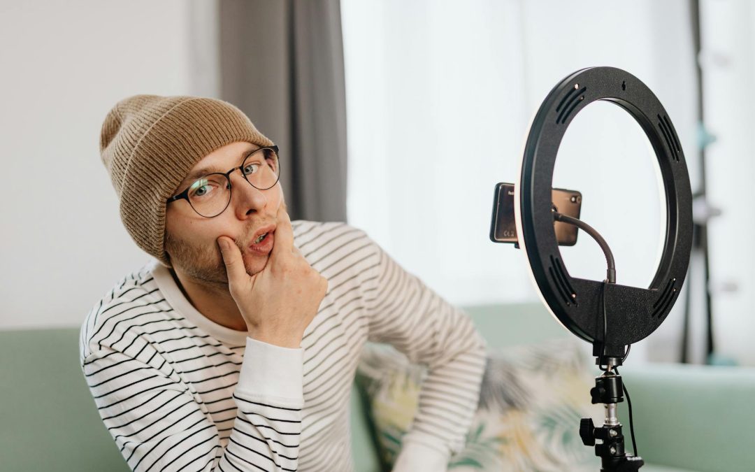 a man wearing white striped shirt and brown beanie thinking on what to vlog