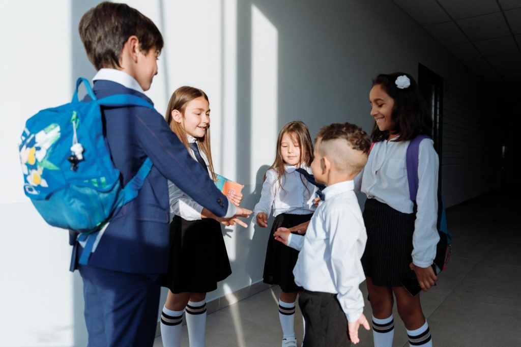 Current image: children in school uniform playing rock paper scissors