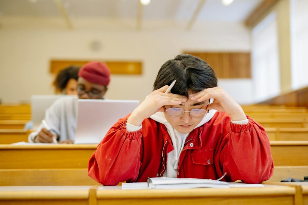 Current image: man in red jacket studying at a classroom
