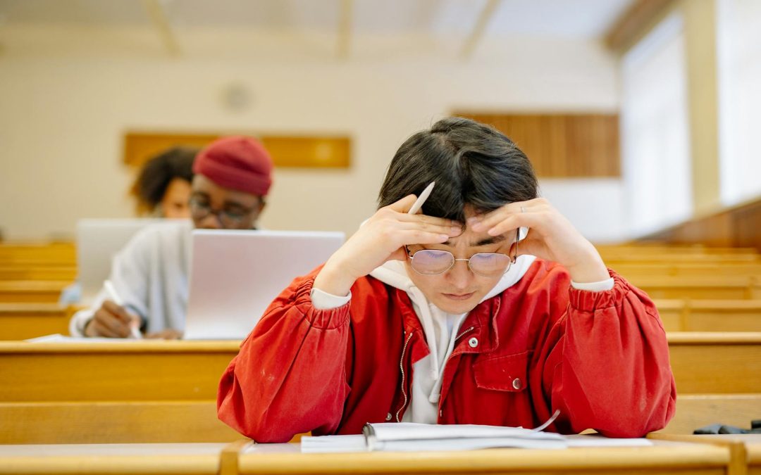 man in red jacket studying at a classroom