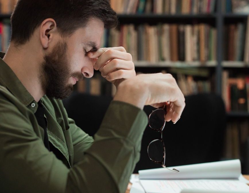 man holding his eyeglasses