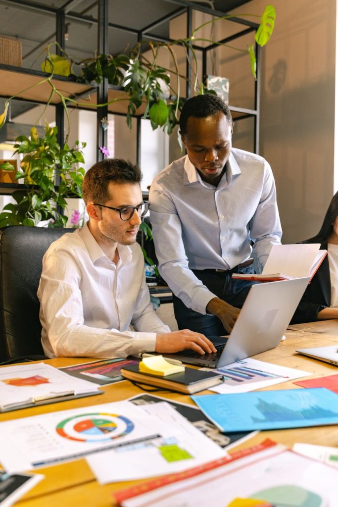 Current image: men working in a team in an office with potted plants