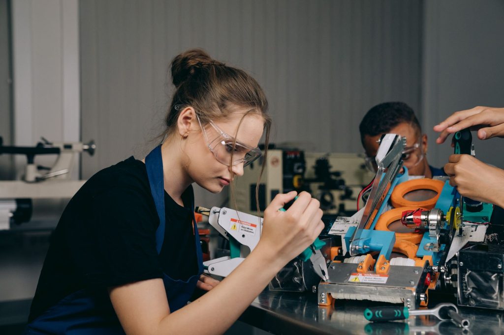 Current image: a woman in a black shirt holding pliers