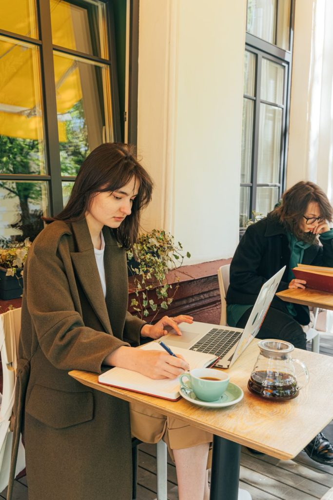 Current image: a woman working while in the coffee shop