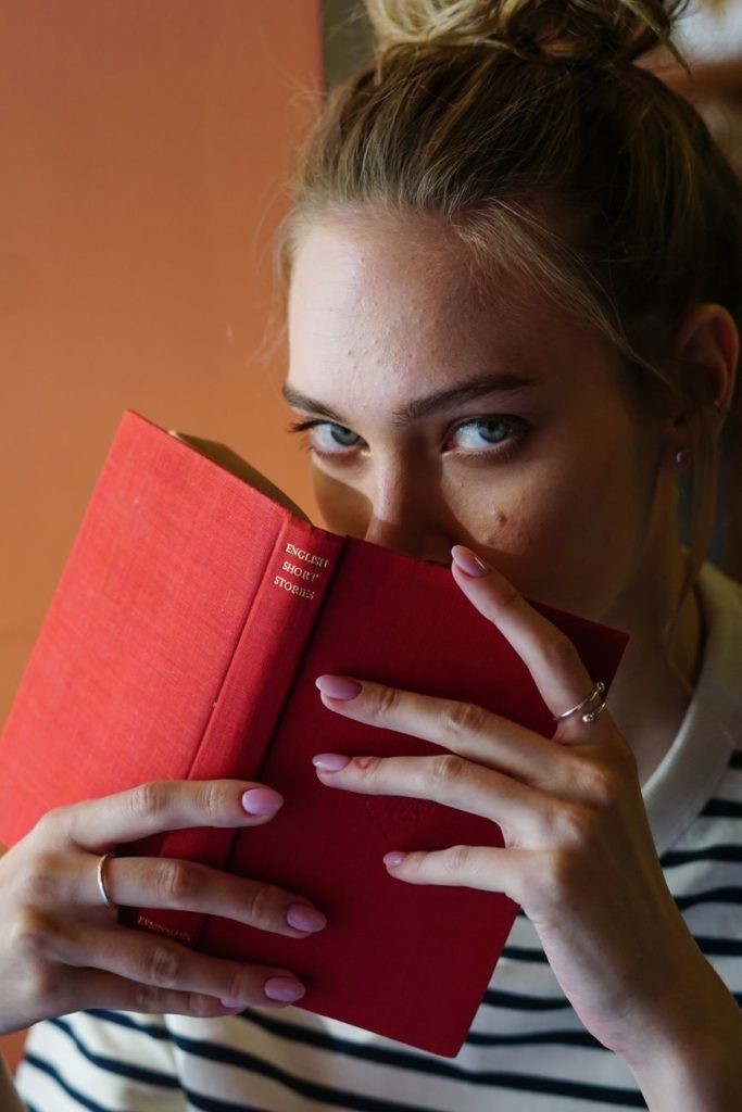 Current image: close up shot of a woman holding a book