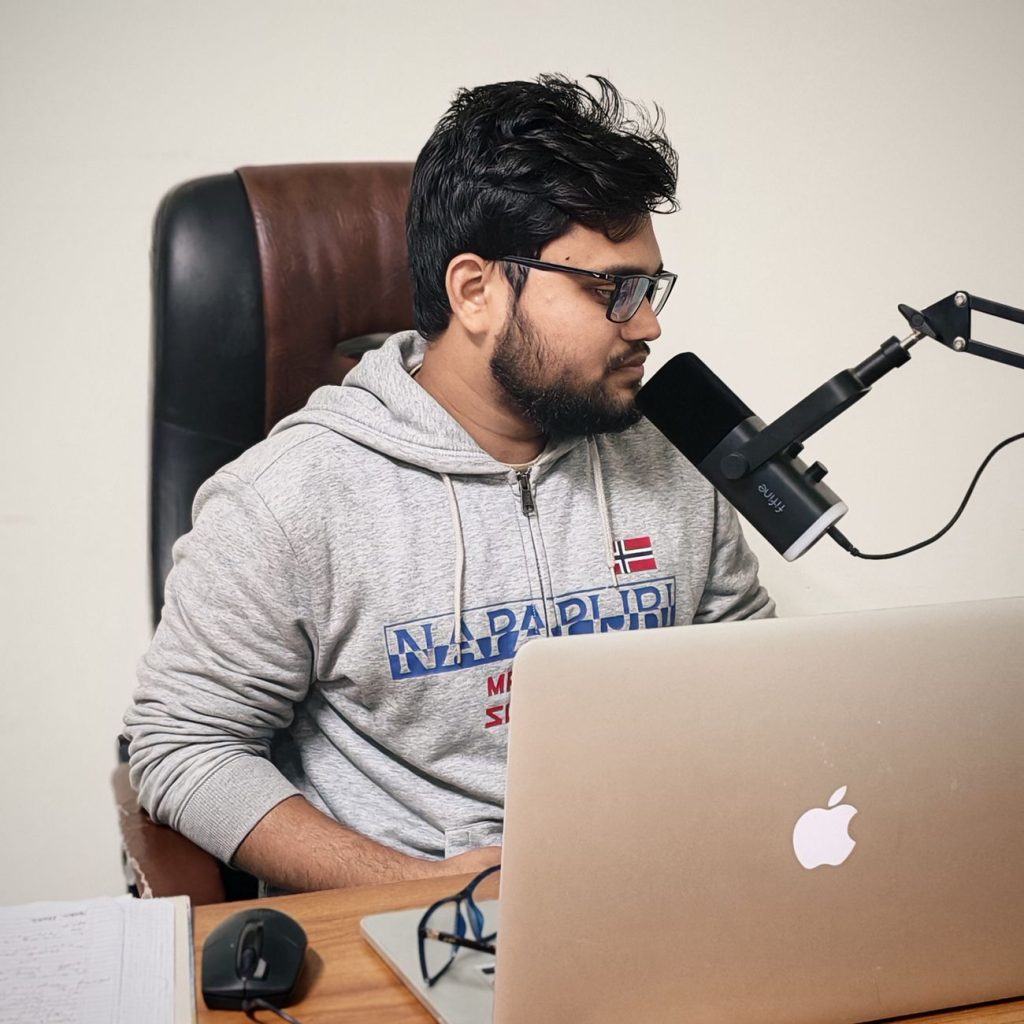 Current image: young man podcasting at home desk