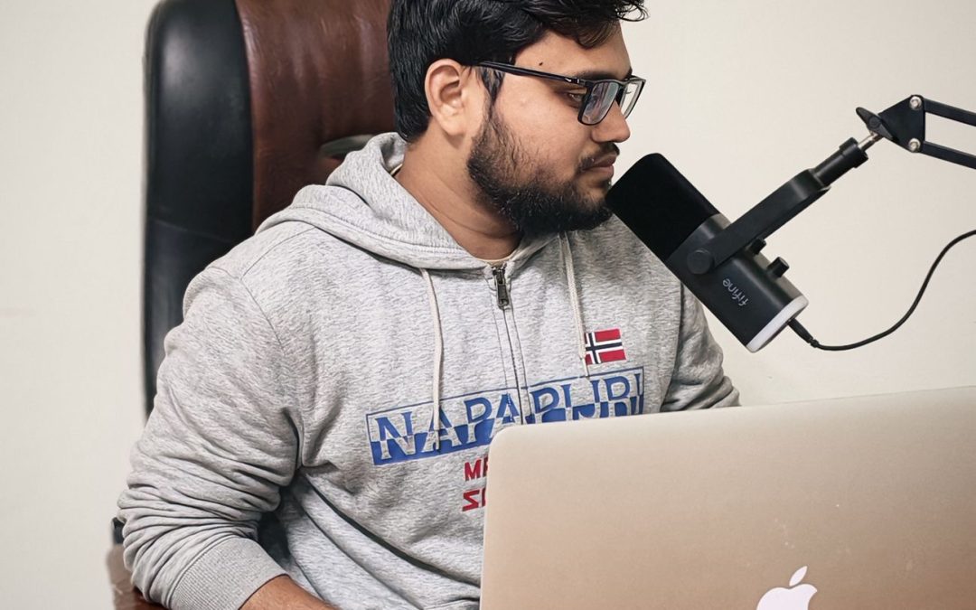 young man podcasting at home desk